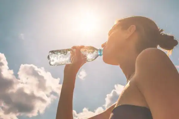 Hydration: The Secret Ingredient for a Toned Stomach and Enhanced Fitness 3 Image of woman drinking water to hydrate Smethwick after run.