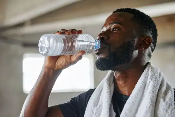 Hydration: The Secret Ingredient for a Toned Stomach and Enhanced Fitness 1 Image of man drinking water to improve hydration Smethwick after work out.